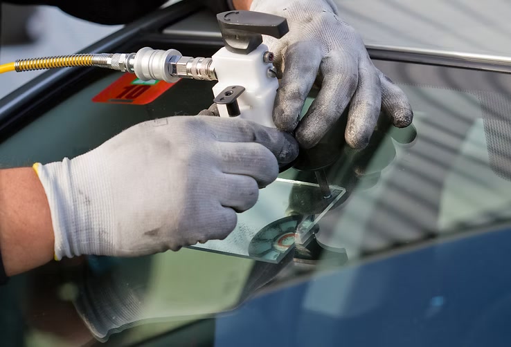Certified technician repairing a small windshield chip with a resin injector at Low Price Auto Glass in Dublin, CA